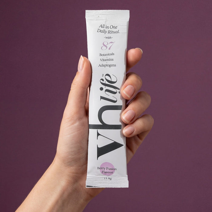 A hand holding a VH Life sachet