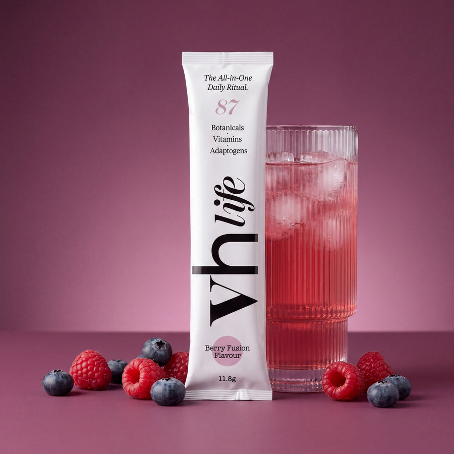 A VH Life sachet beside a glass of the berry drink