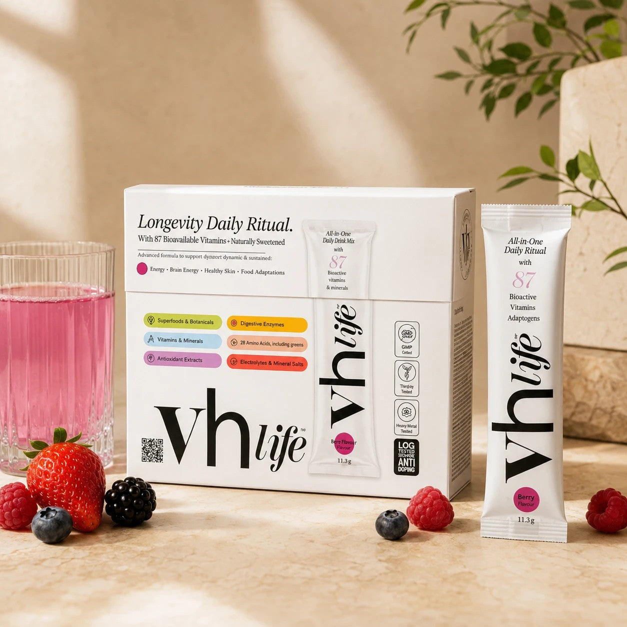 A vh life box and Berry sachet beside a glass of berry drink and fresh berries