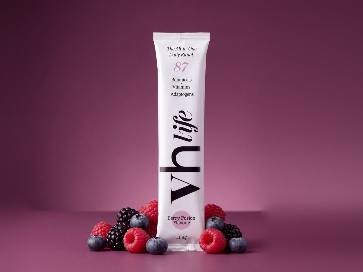 A VH Life berry sachet standing among fresh raspberries, blackberries and blueberries