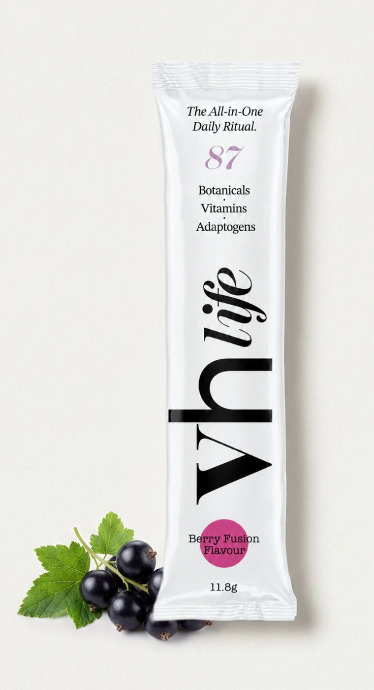A VH Life Berry Fusion sachet photographed beside a sprig of fresh blackcurrants