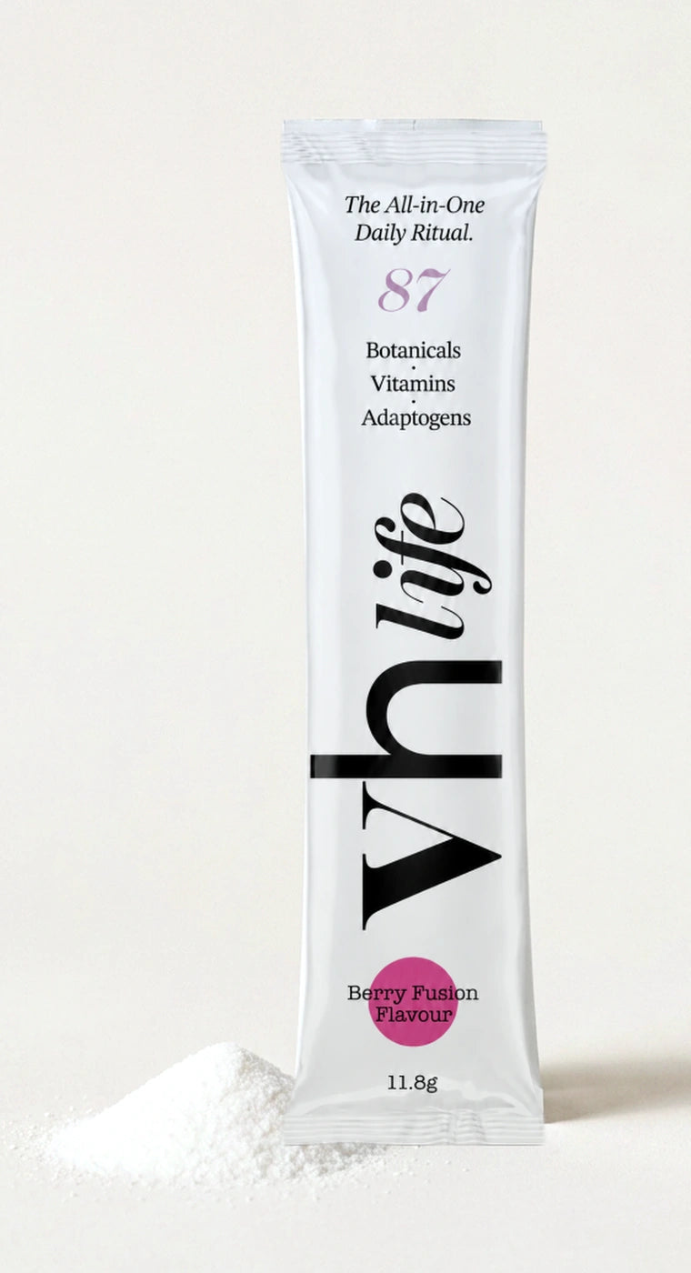 A VH Life Berry Fusion sachet photographed beside a pile of fine white amino acid powder